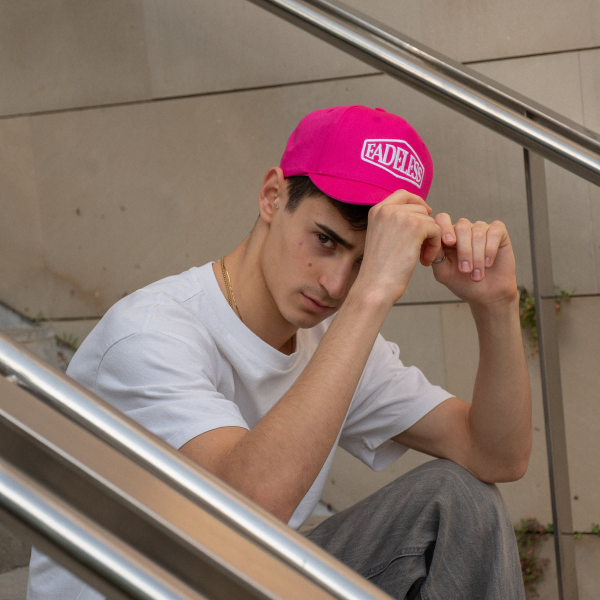 Ung mand med pink Fadeless kasket og hvid t-shirt