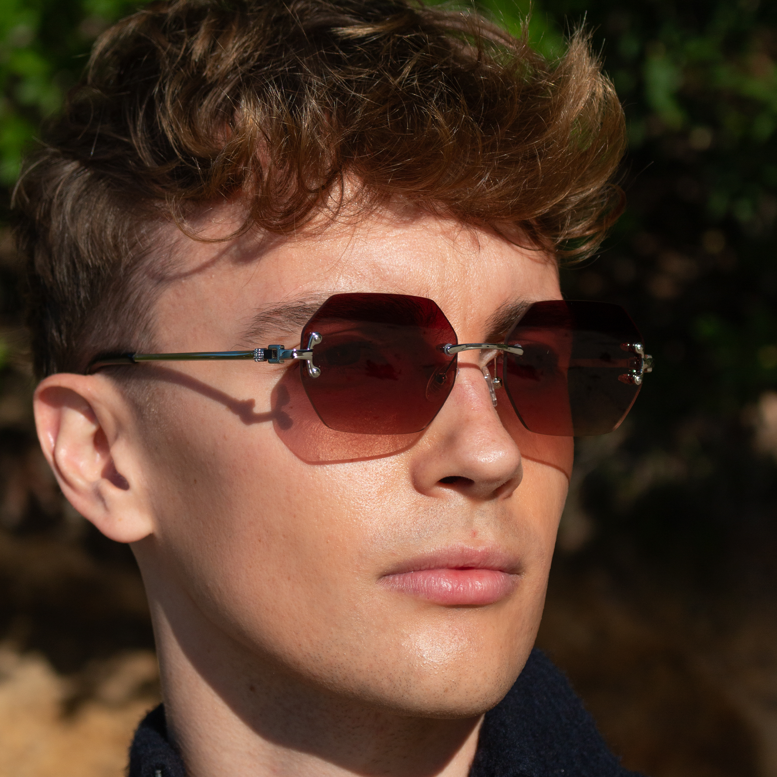 Ung mand med rammeløse solbriller i walnut brown nuance