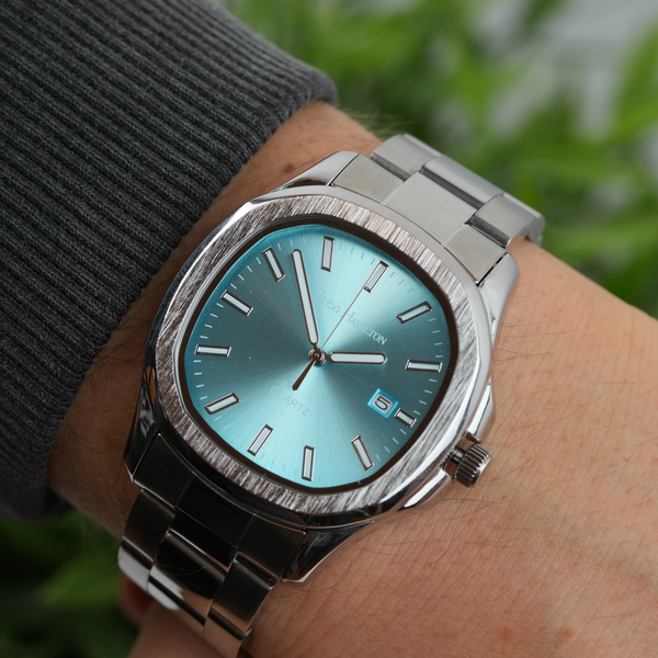 Armbåndsur med turkis urskive og stållænke på håndled