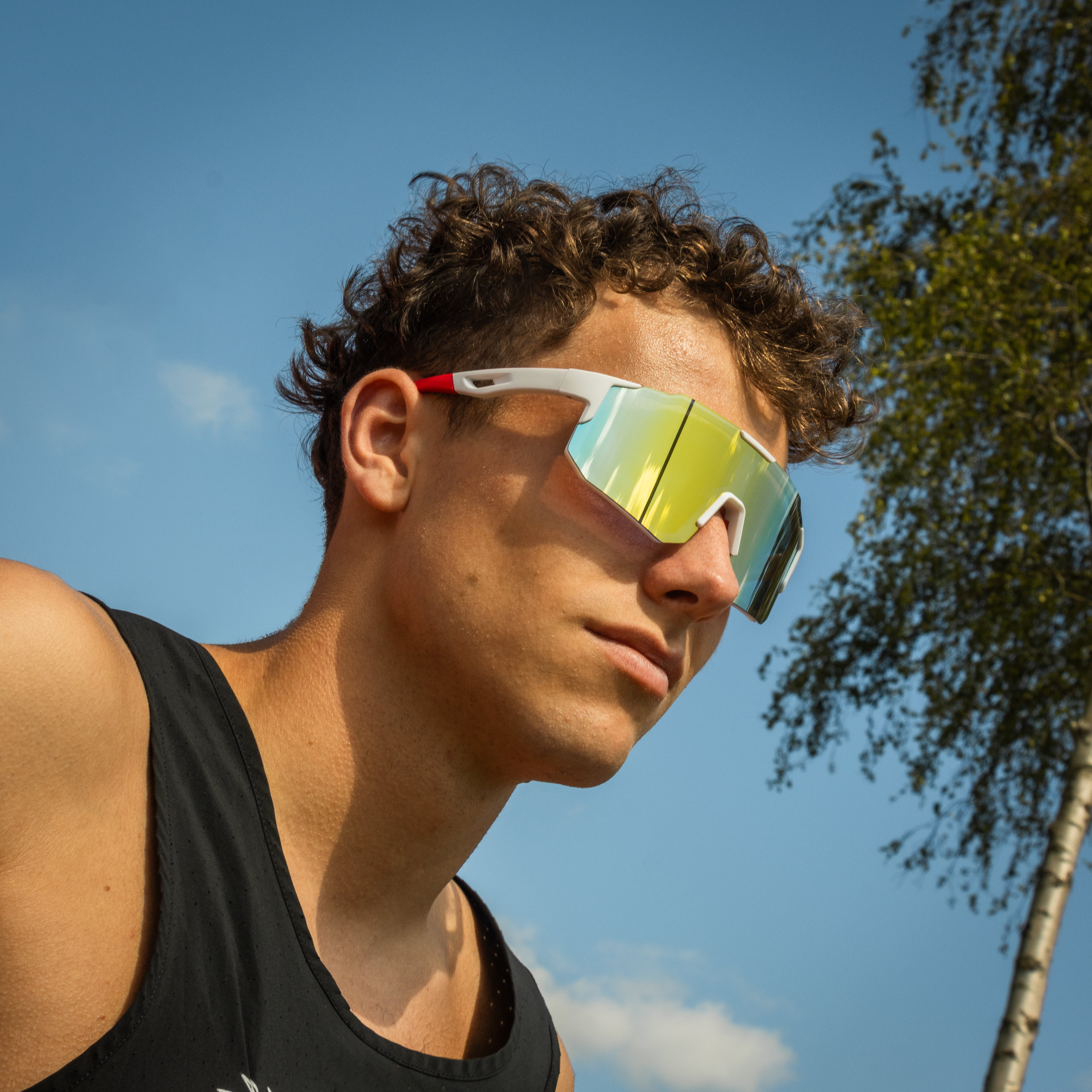 Noire Frost sportsbriller i hvid med gult spejlglas på model udendørs