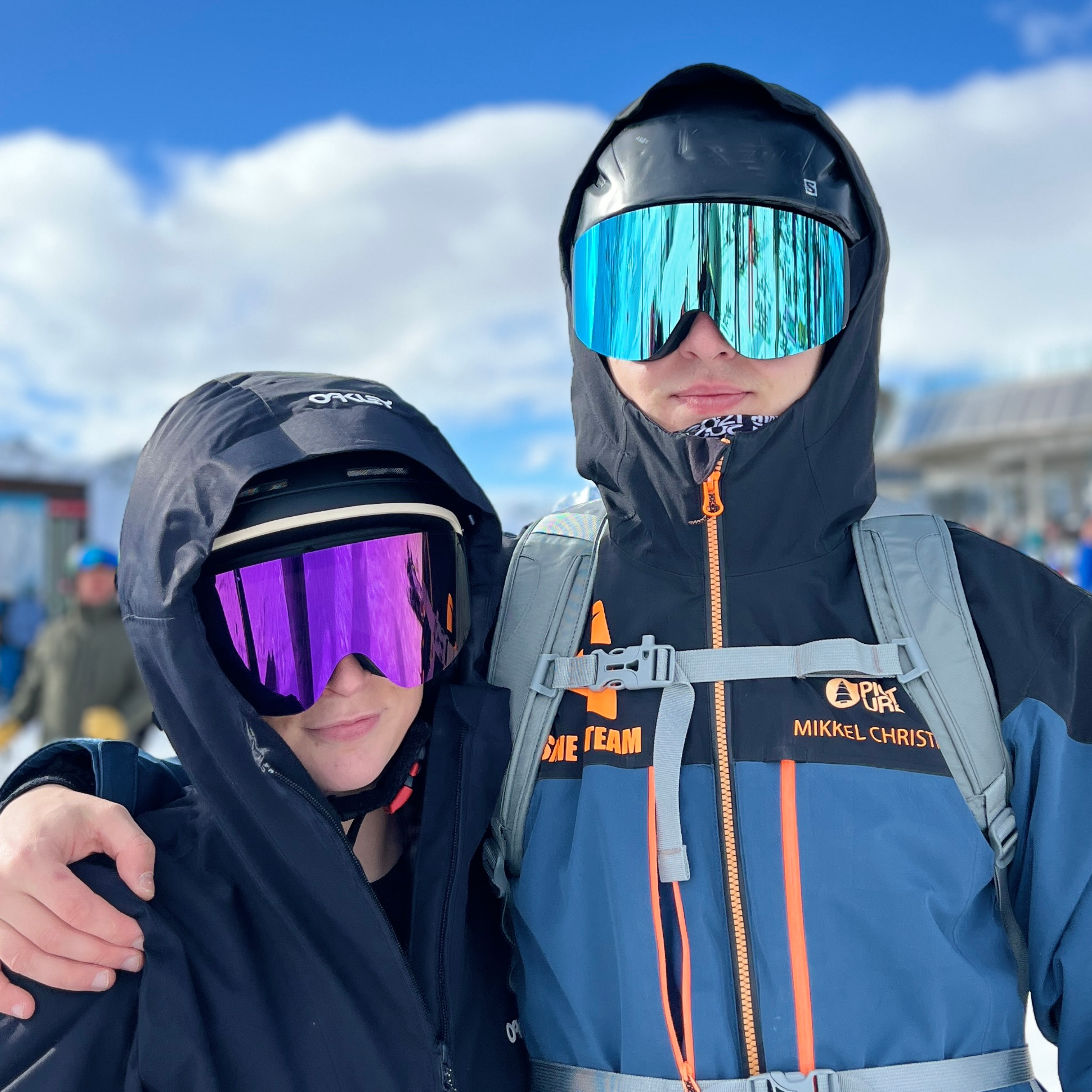 To skiløbere med Glaciér skibriller i lyseblå og lilla spejlglas på bjerg