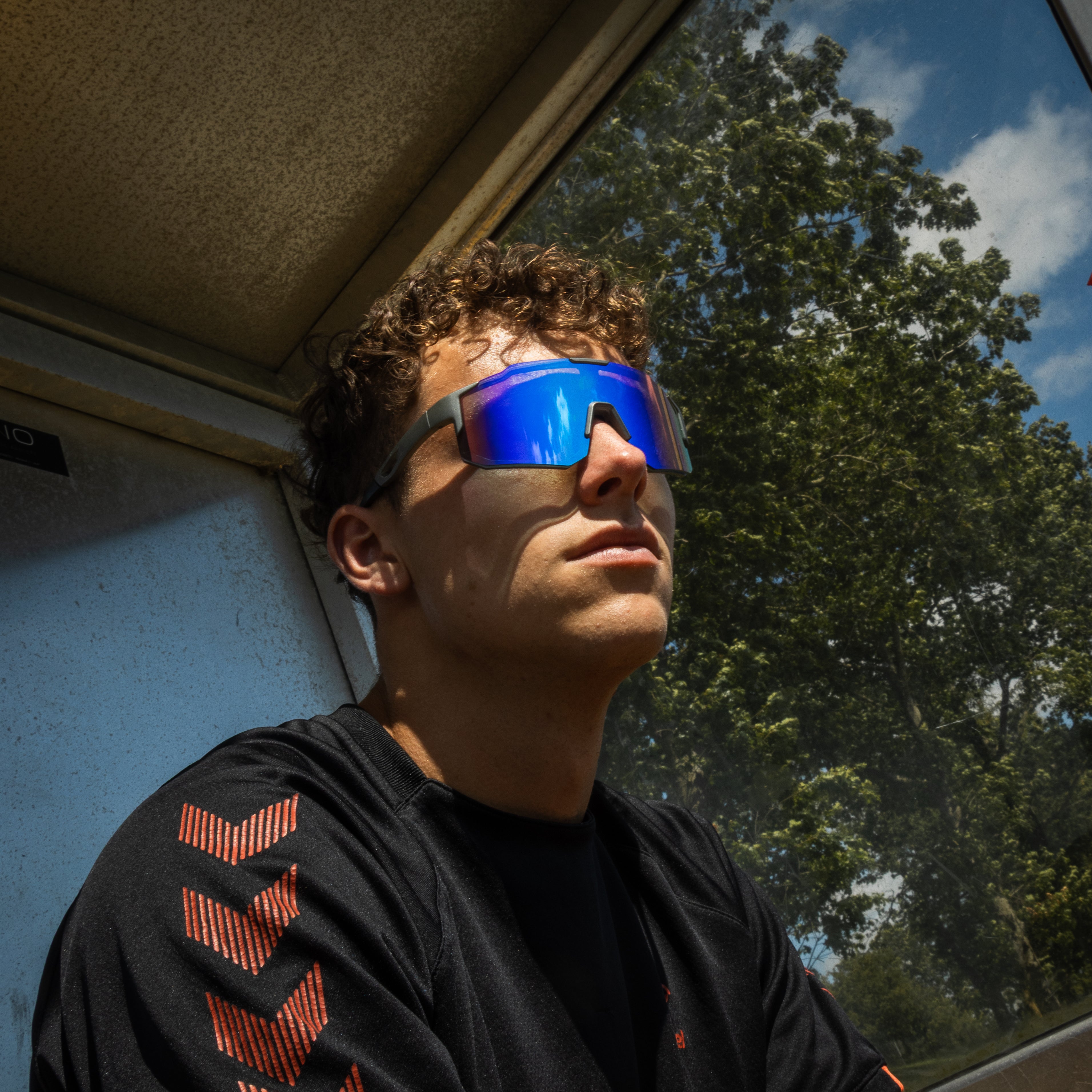 Mand iført Noire Leafy sportsbriller med blå spejlglas i sollys