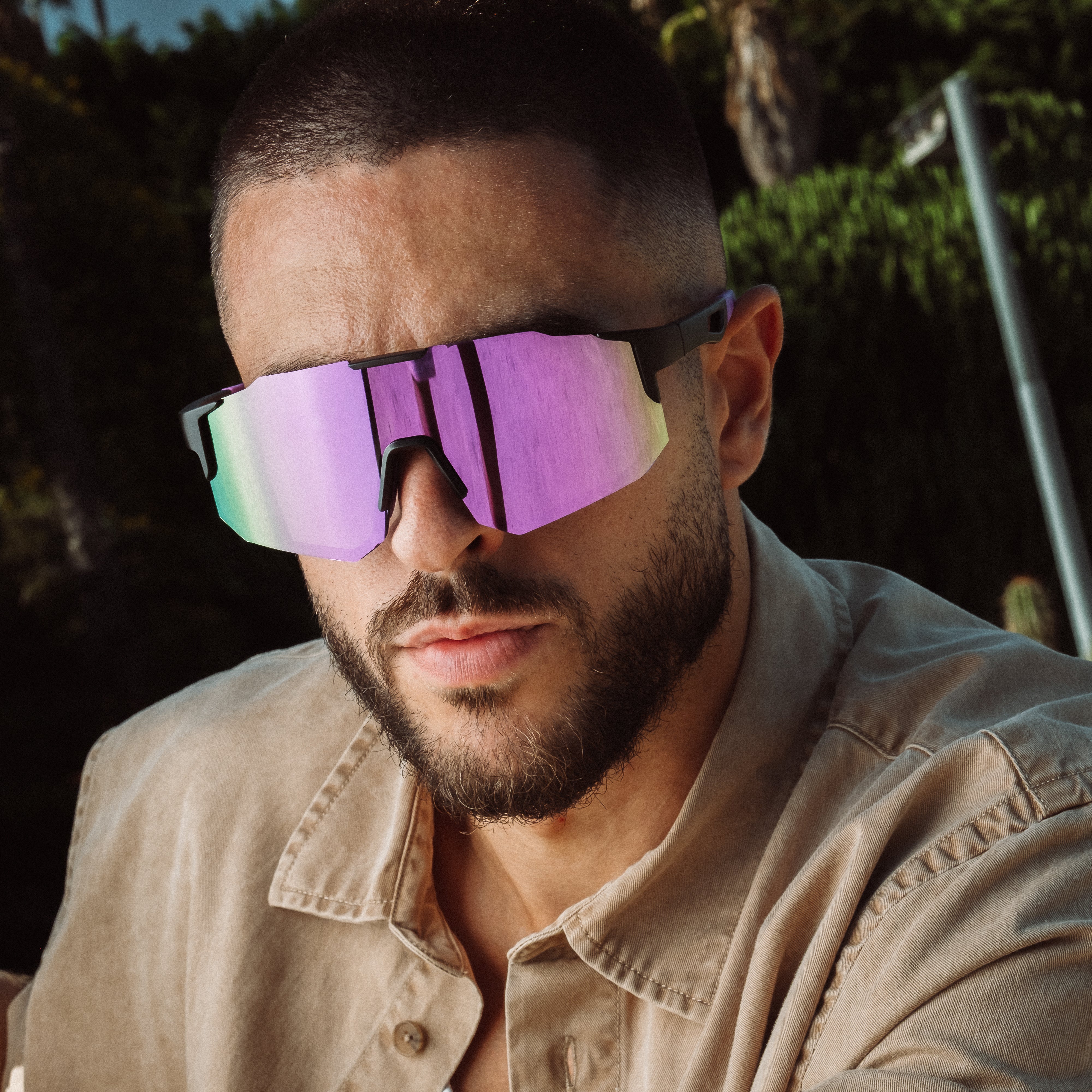 Mand iført Noire Grape sportsbriller med lilla spejlglas i sollys