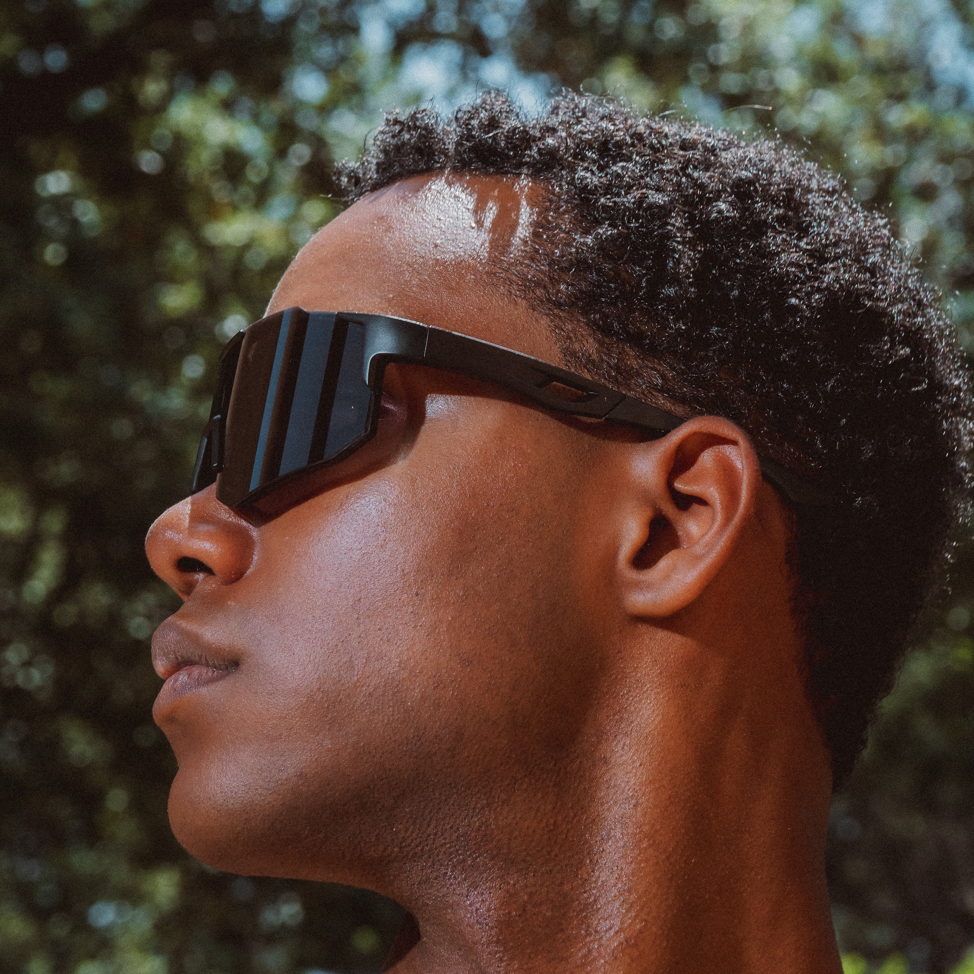 Noire Blackout sportsbriller i sort med futuristisk design båret udendørs i profil