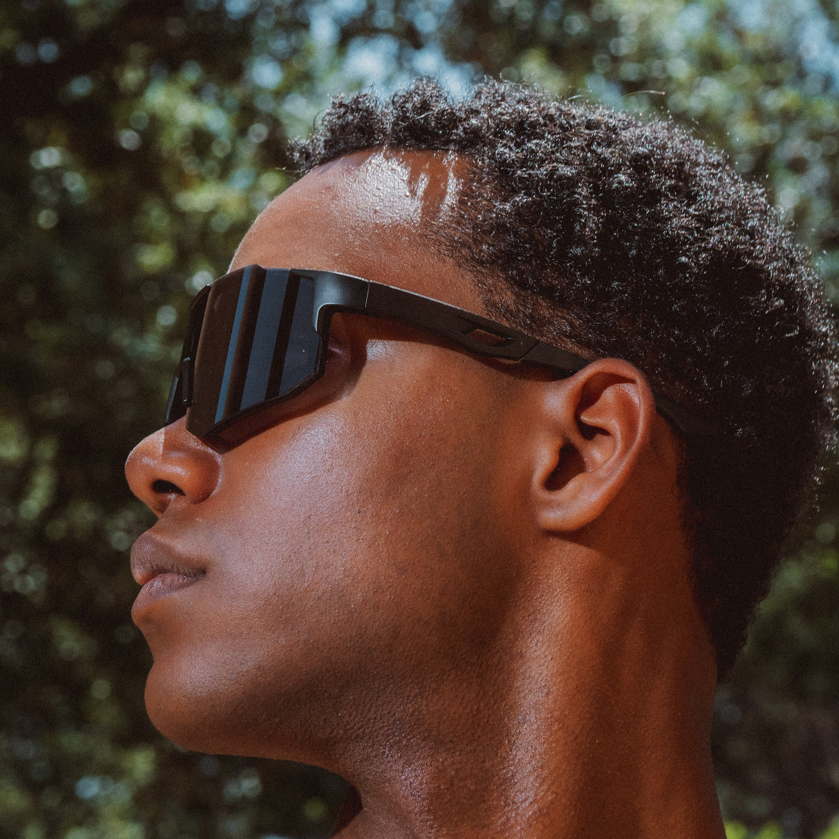 Noire Blackout sportsbriller i sort med futuristisk design båret udendørs i profil