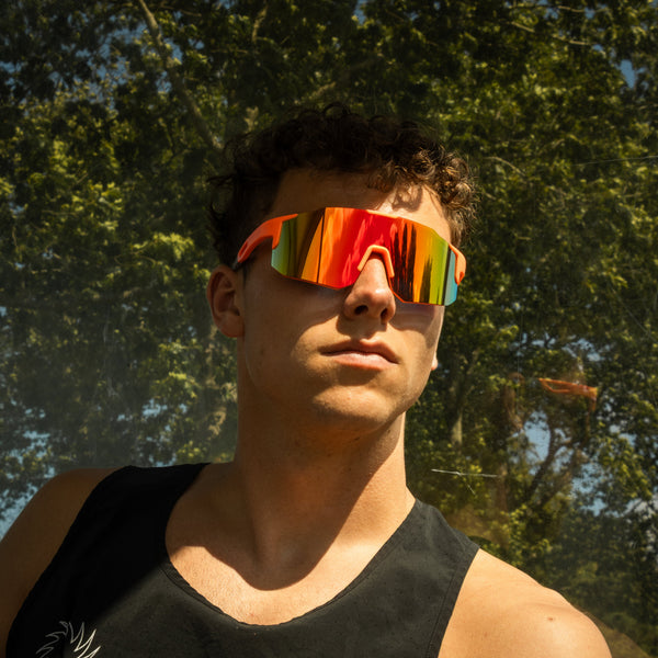 Mand med orange spejlreflekterende sportsbriller i sollys