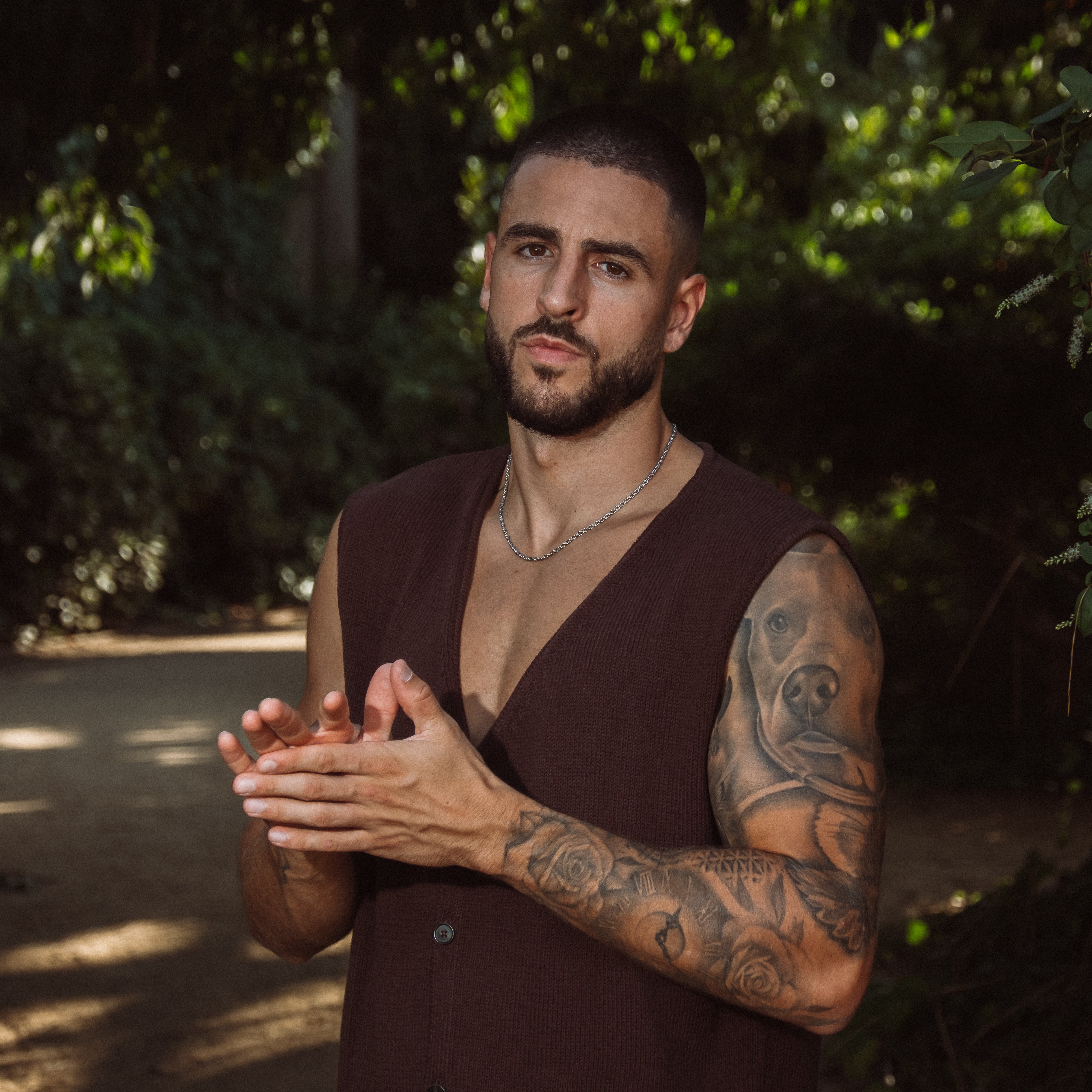 Mand med sølvfarvet rope chain halskæde og tatoveringer