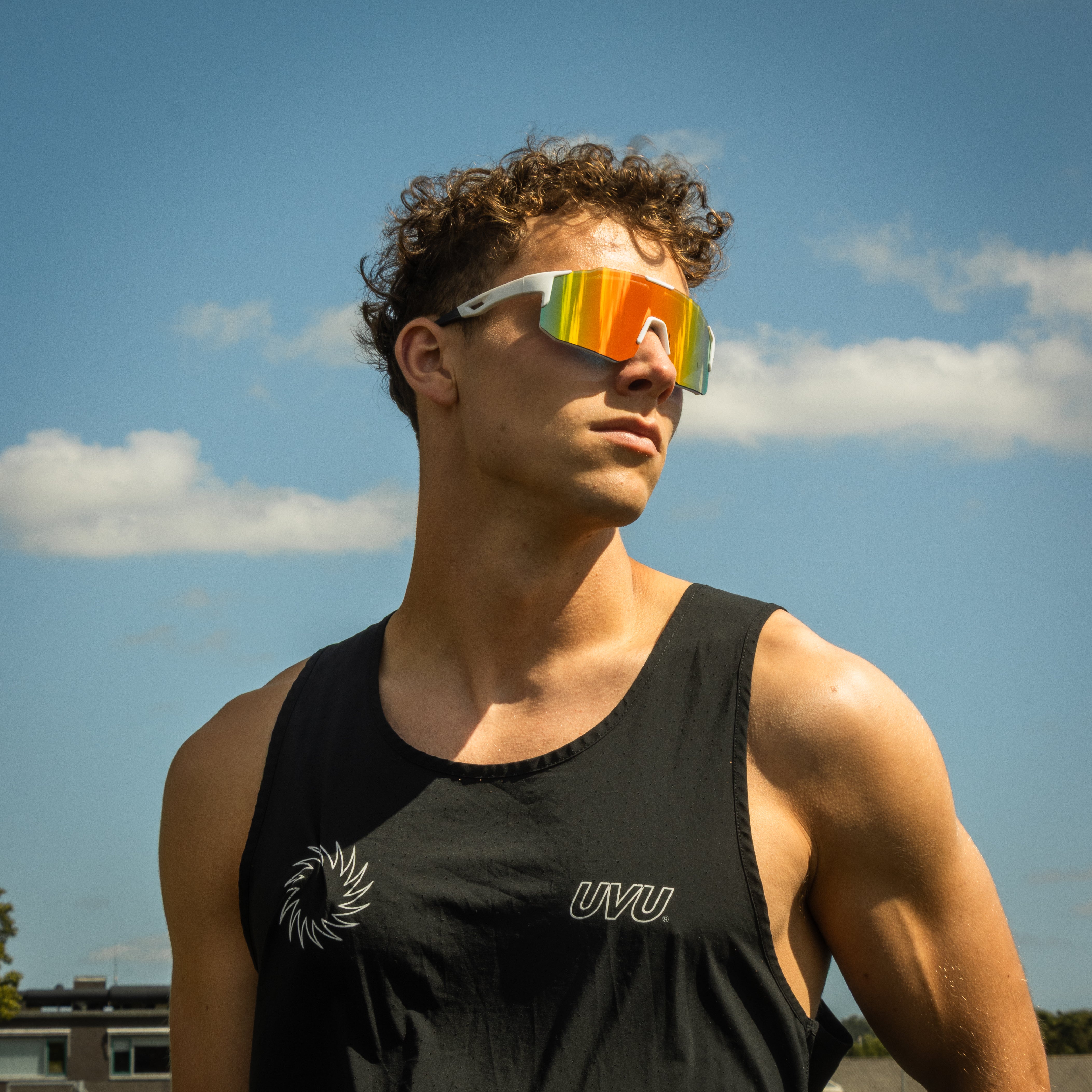 Sportsbriller med hvid stel og orange spejlglas i udendørs sollys