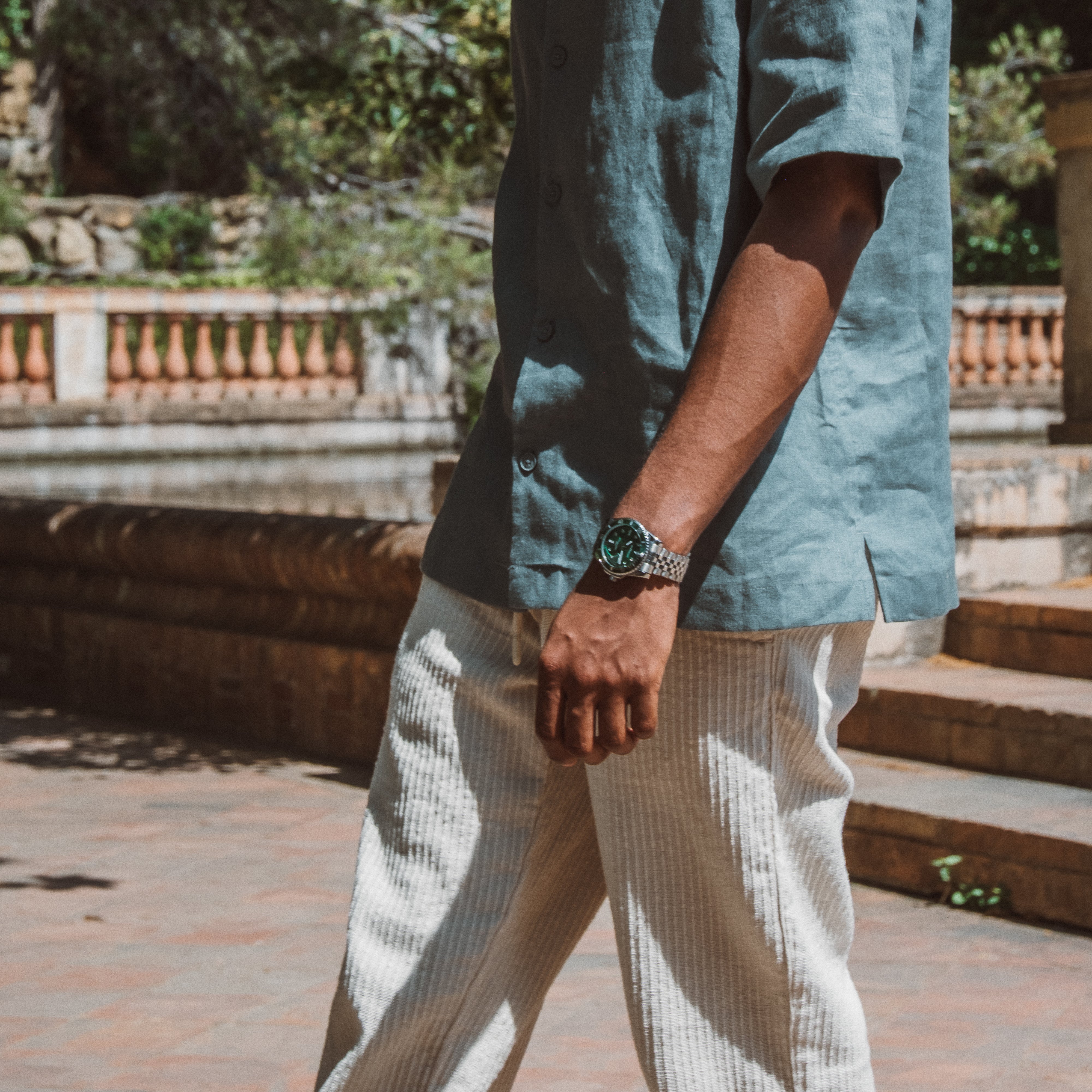 Mand iført mint linenskjorte og beige bukser med armbåndsur