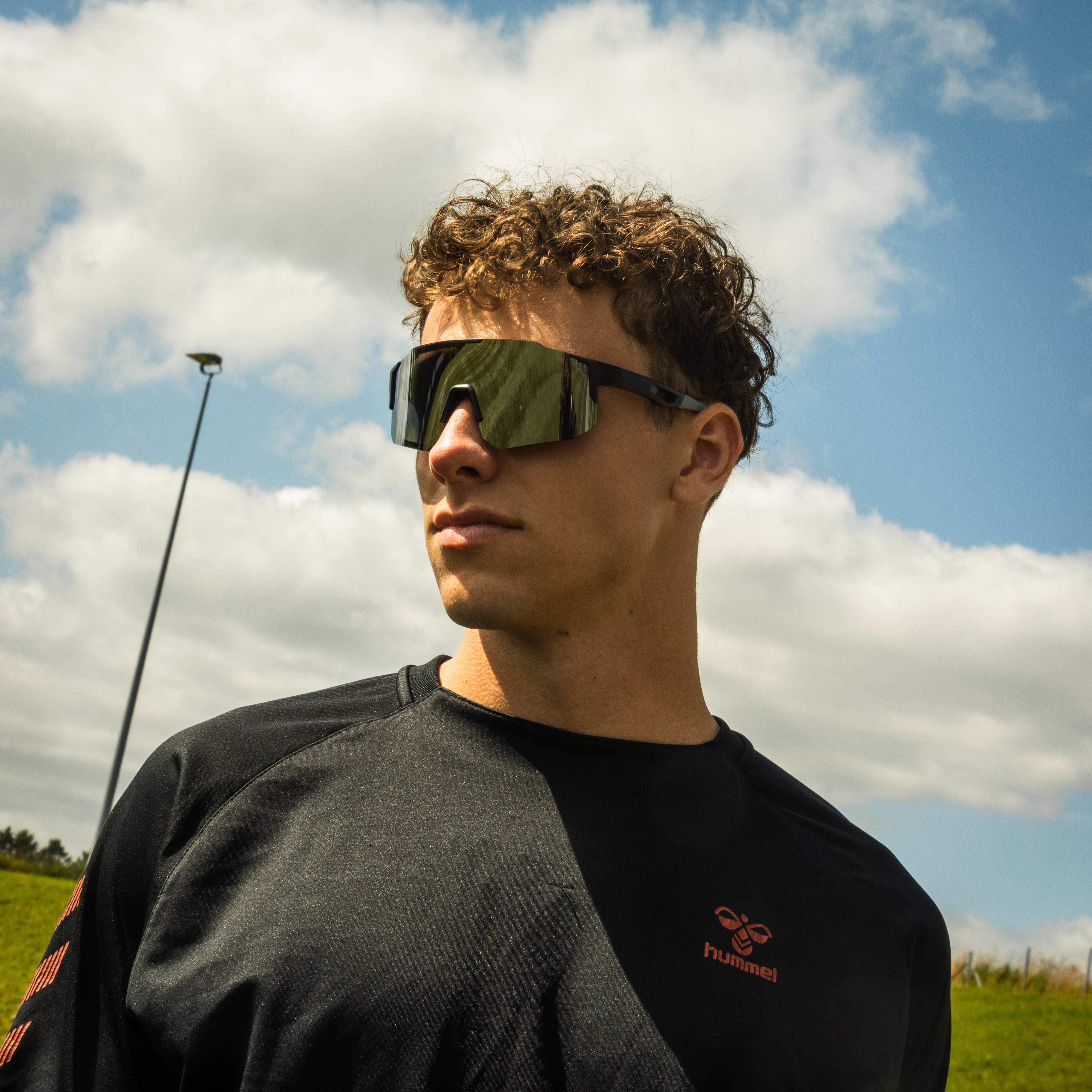 Mand med grå sportsbriller fra Atlithé under blå himmel