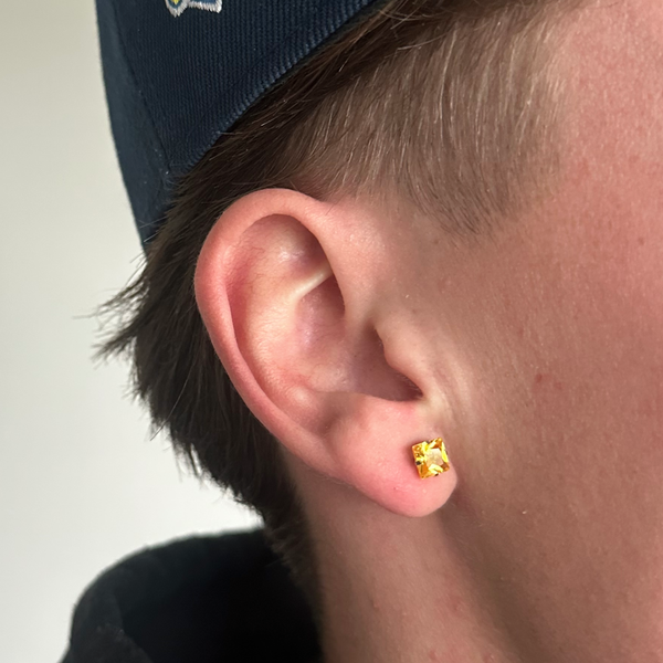 Gul ørering i 6mm på øre med kasket