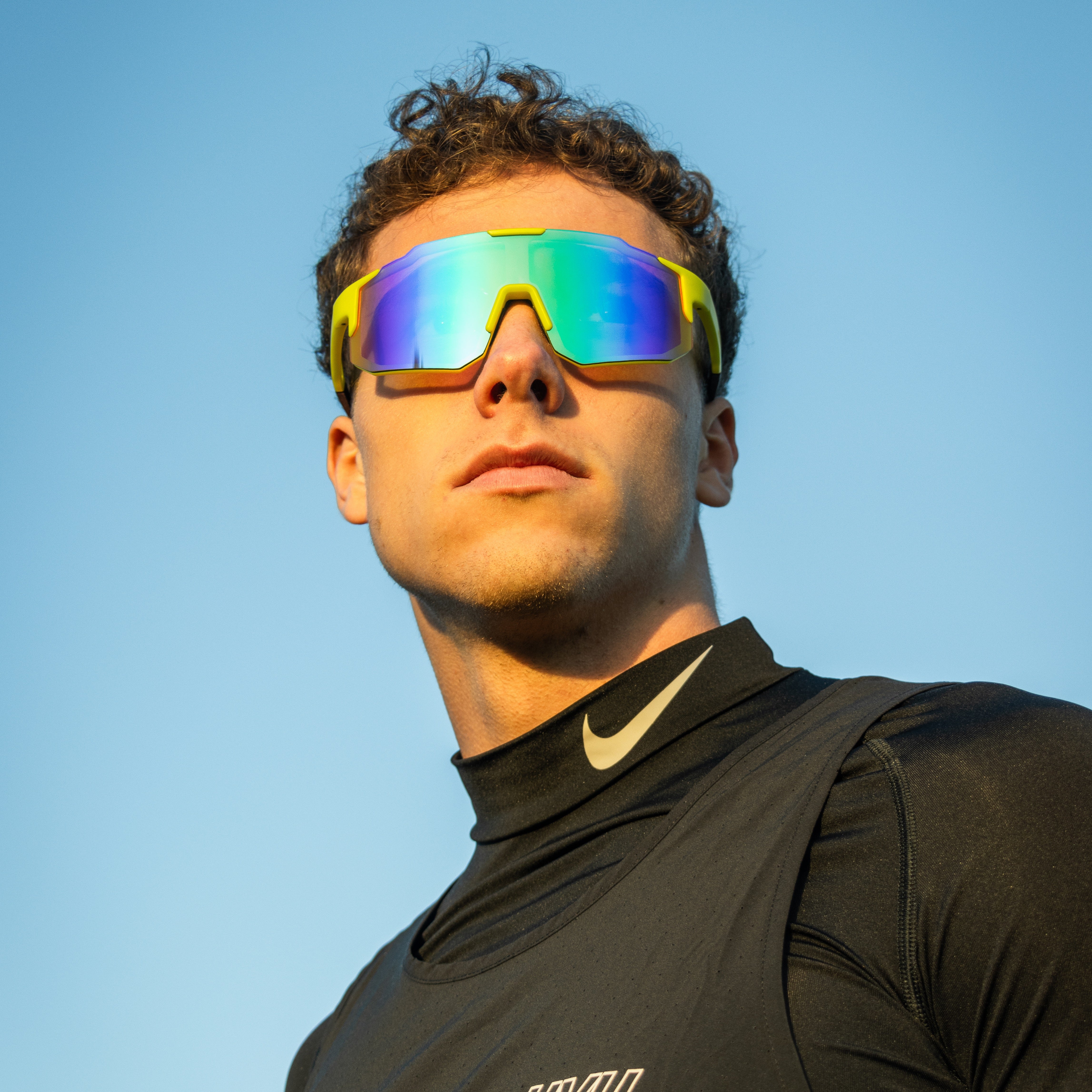 Sportsbriller med gule spejlglas og grøn-blå refleksion