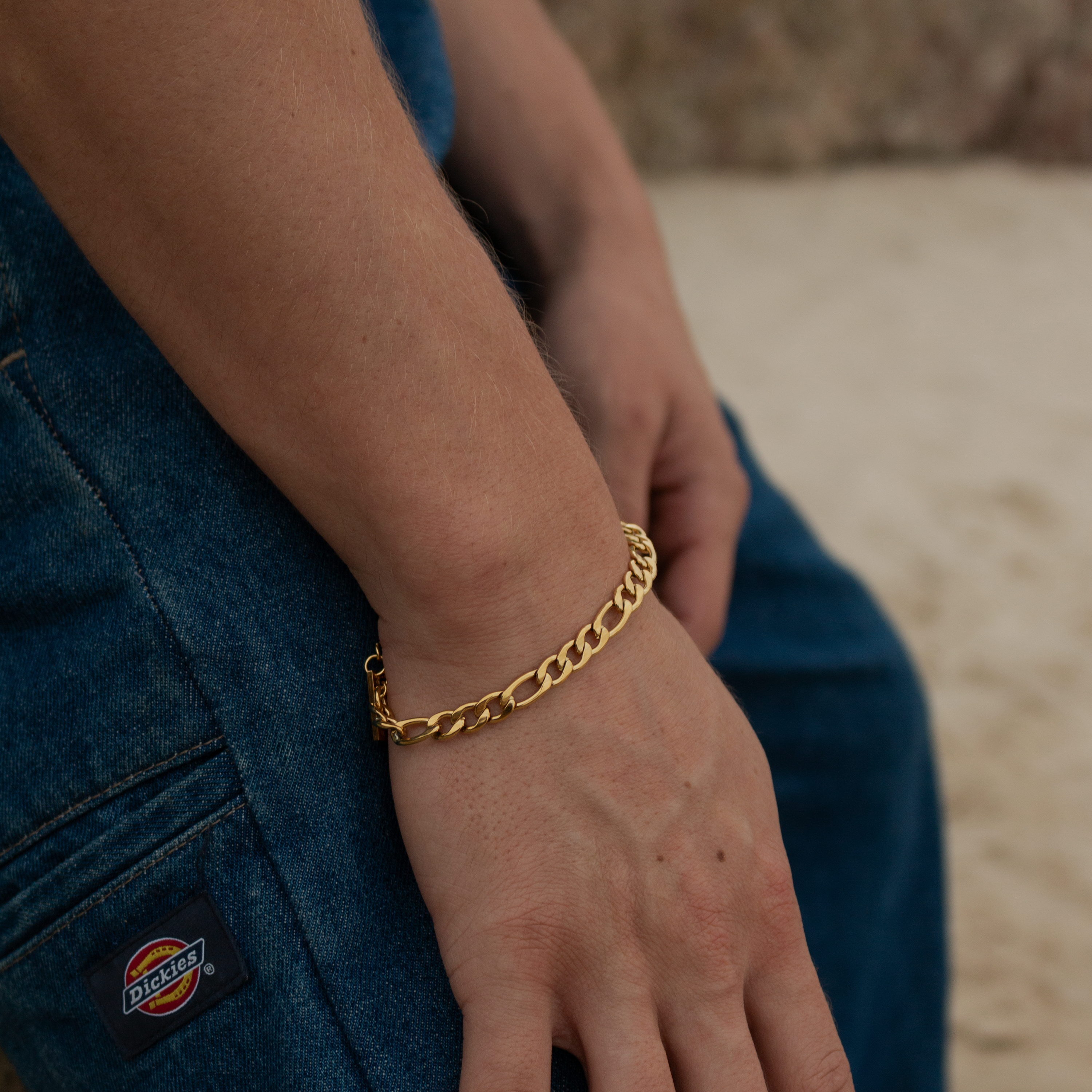 Guldbelagt armbånd i Figaro-kæde på håndled