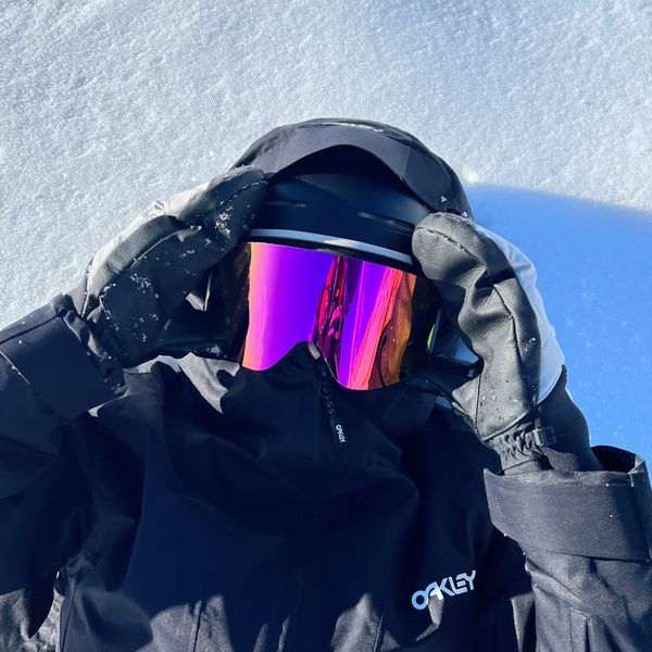 Glaciér skibriller med lyserøde spejlglas og sort stel på snedækket baggrund