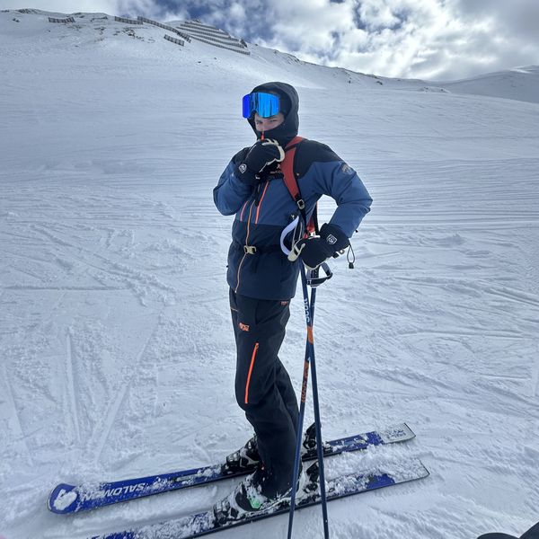 Skiløber med Glaciér skibriller i mørkeblå med blå spejlglas på snedækket piste