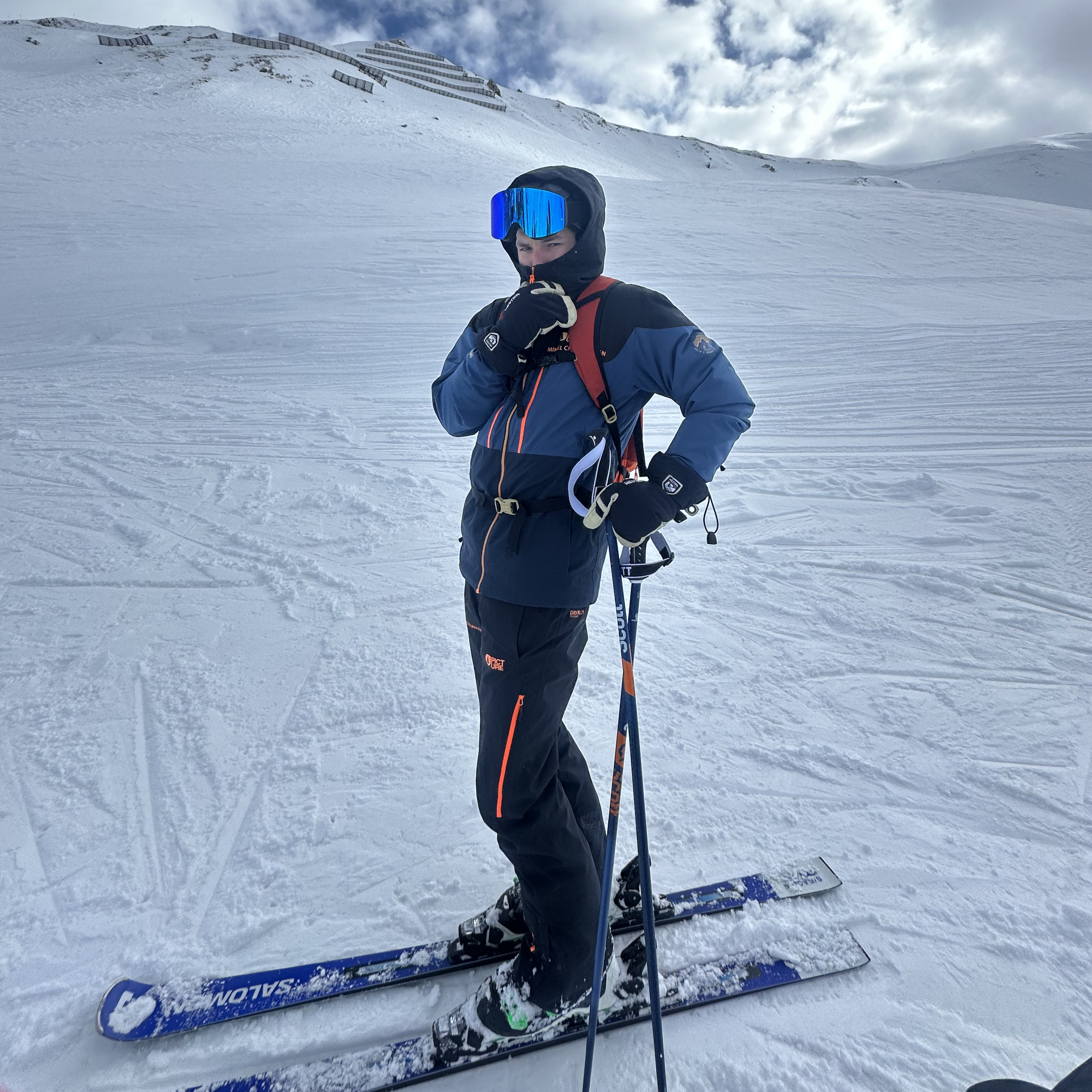 Skiløber med Glaciér skibriller i mørkeblå med blå spejlglas på snedækket piste