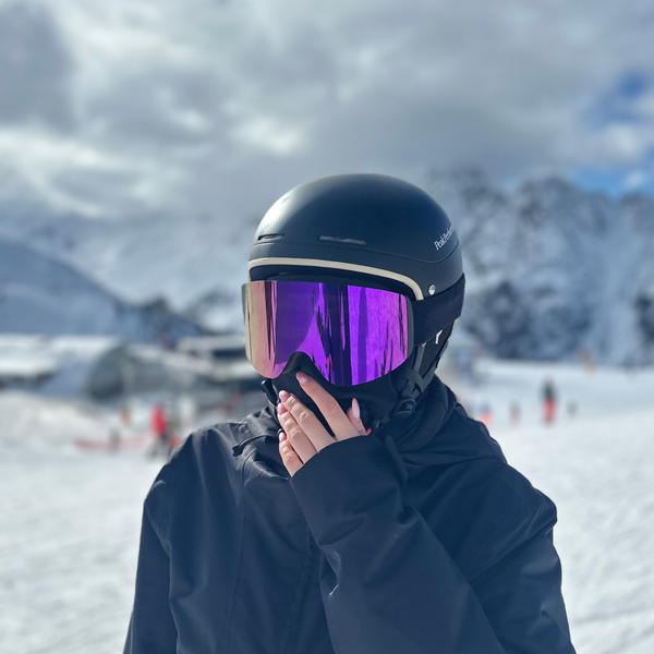 Skibriller med lilla spejlglas og sort hjelm vist i snelandskab