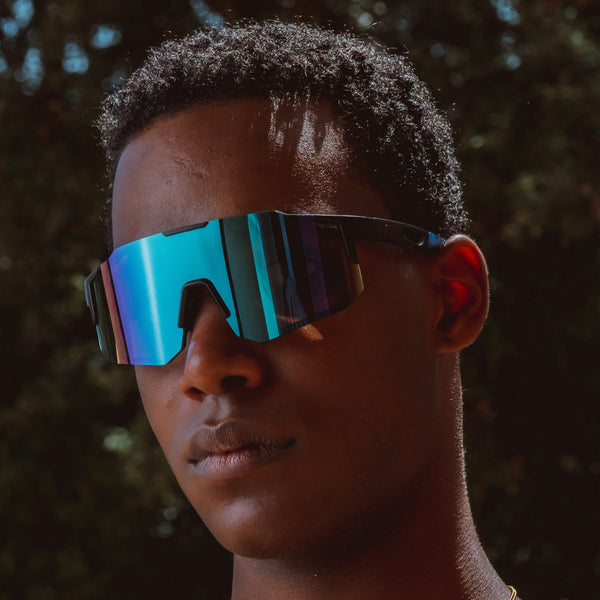 Sportsbriller med blå spejlglas vist forfra på model i sollys
